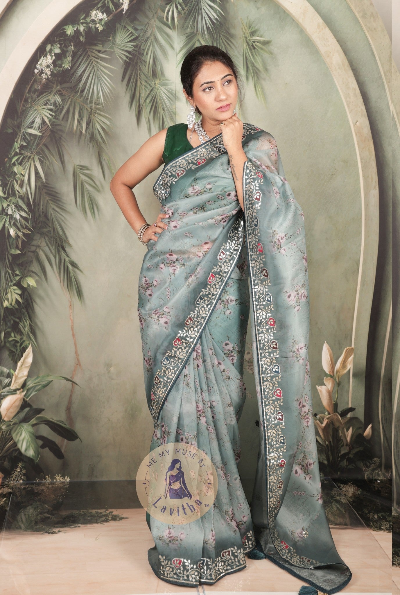 Our muse is wearing a rich premium floral digital printed organza Pastel Greyish Green saree with Gota Patti work on the border and designer pallu. This festive-wear saree is part of the Dilqash collection of Me My Muse by Lavitha