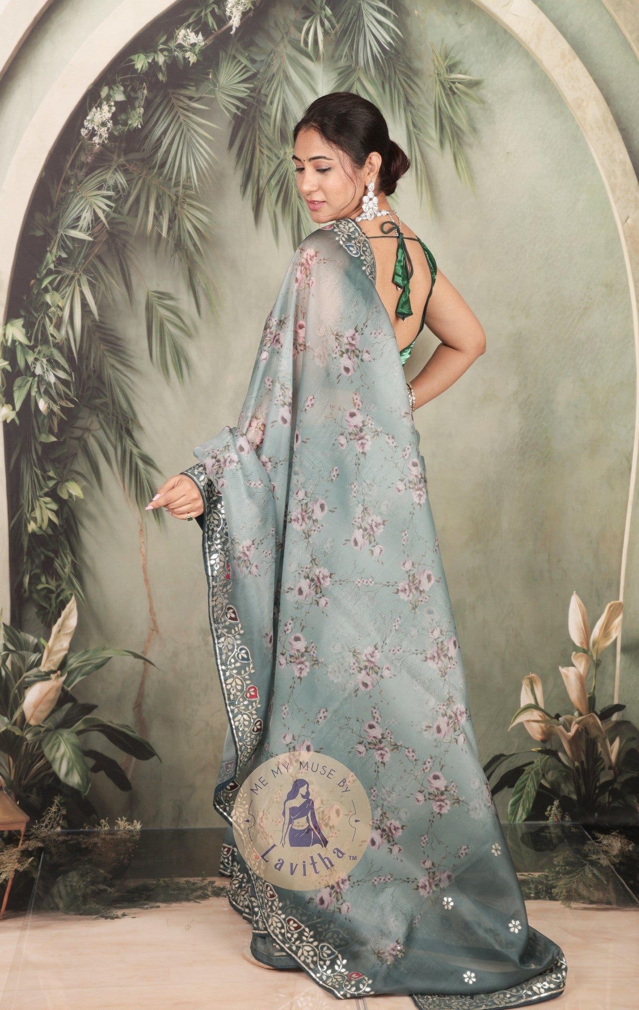 Our muse is wearing a rich premium floral digital printed organza Pastel Greyish Green saree with Gota Patti work on the border and designer pallu. This festive-wear saree is part of the Dilqash collection of Me My Muse by Lavitha