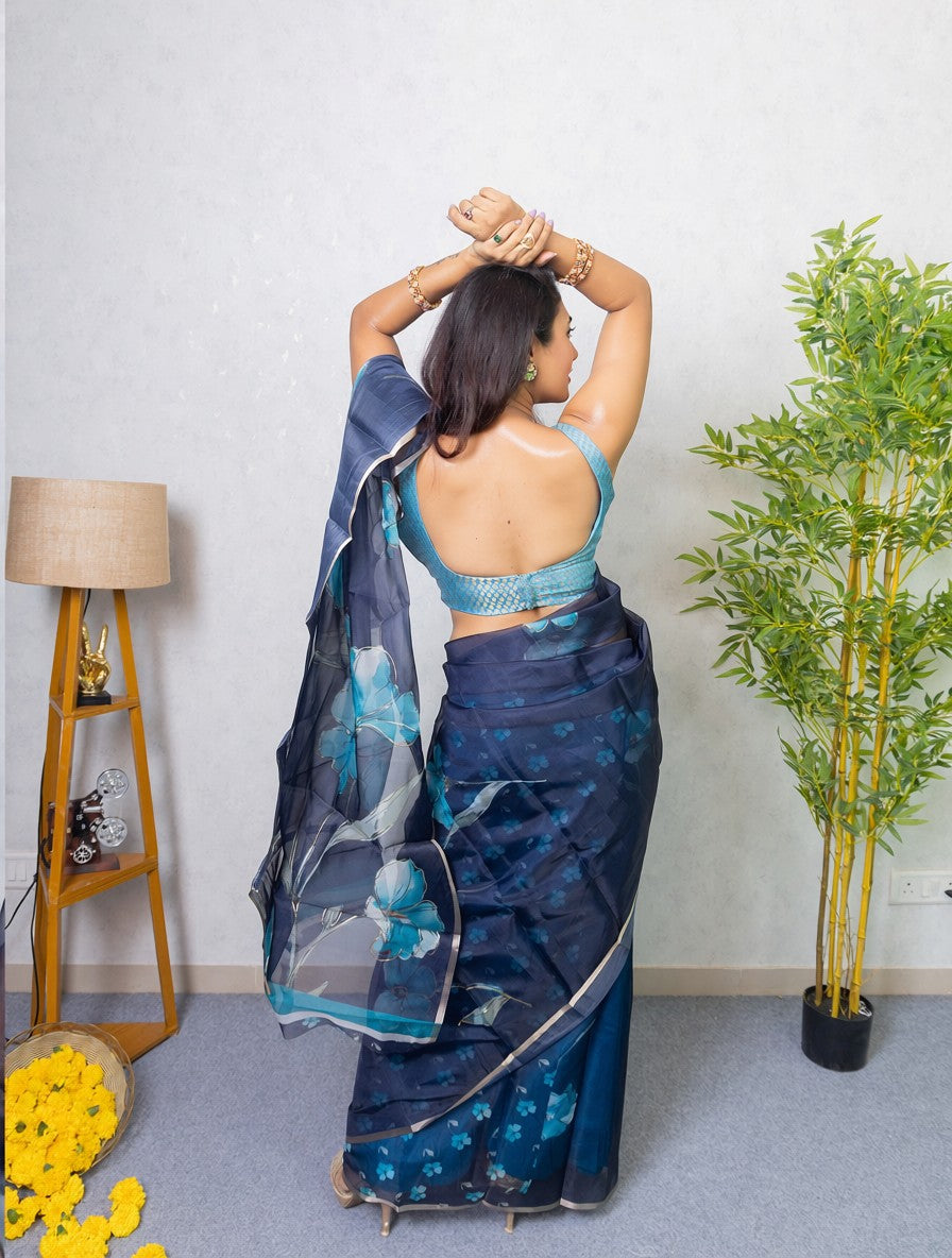 Our muse in a dark blue organza printed saree with floral patterns and thin gold border from Me My Muse by Lavitha