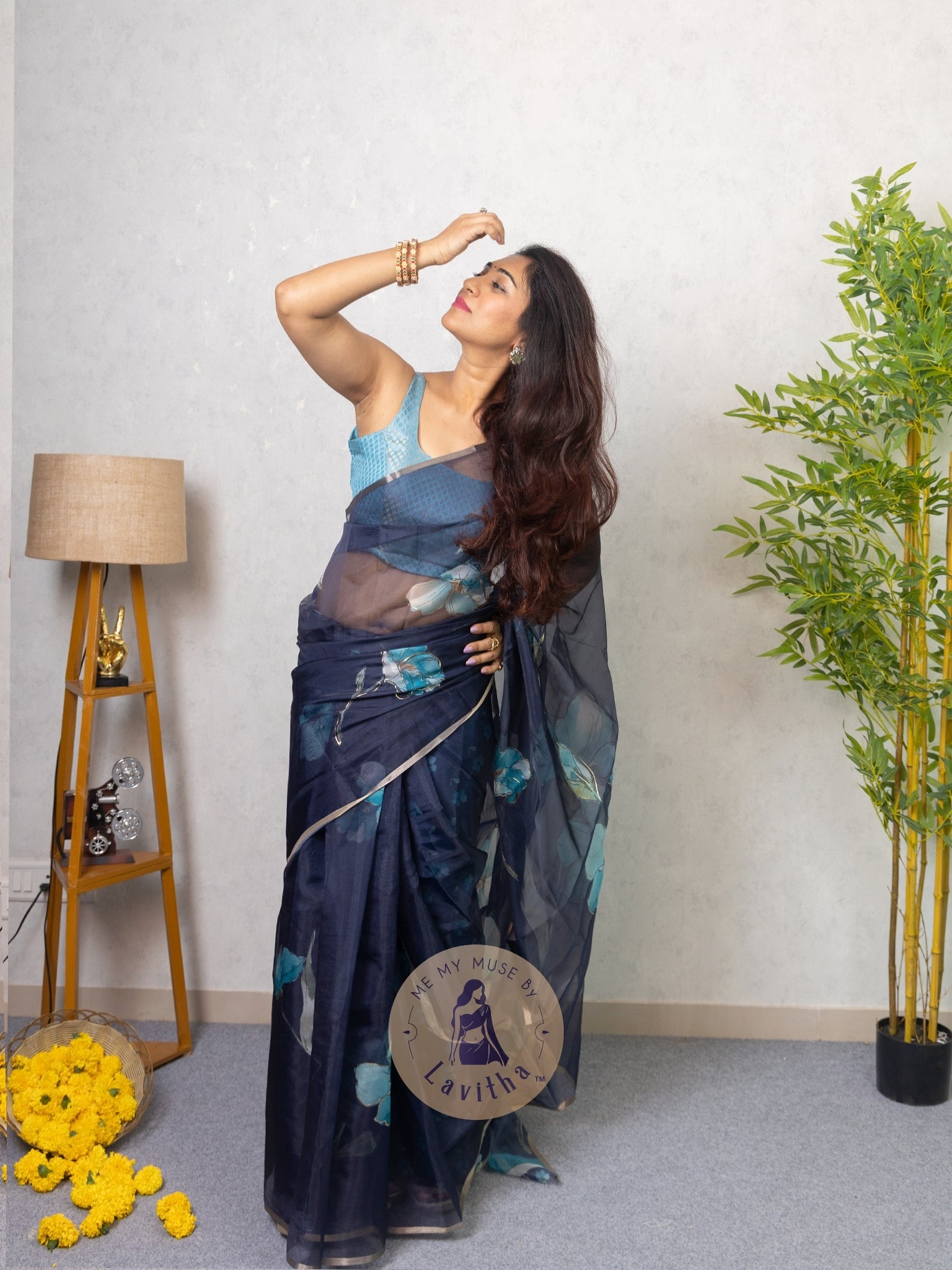 Our muse in a dark blue organza printed saree with floral patterns and thin gold border from Me My Muse by Lavitha