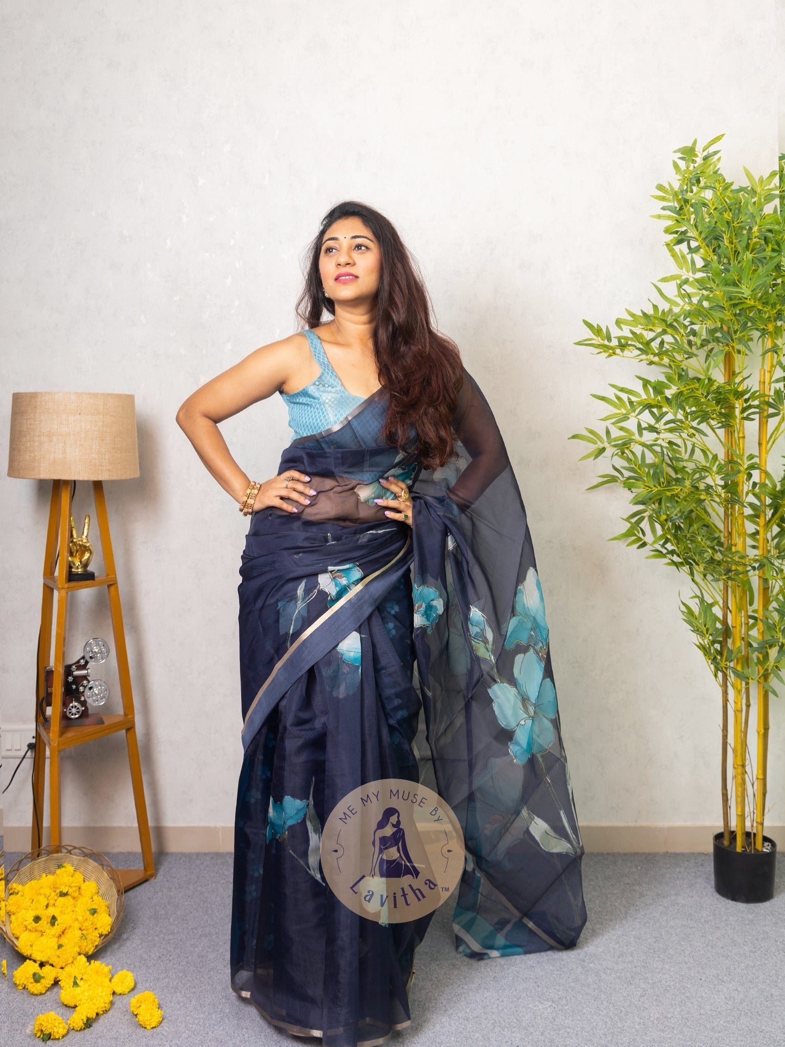Our muse in a dark blue organza printed saree with floral patterns and thin gold border from Me My Muse by Lavitha
