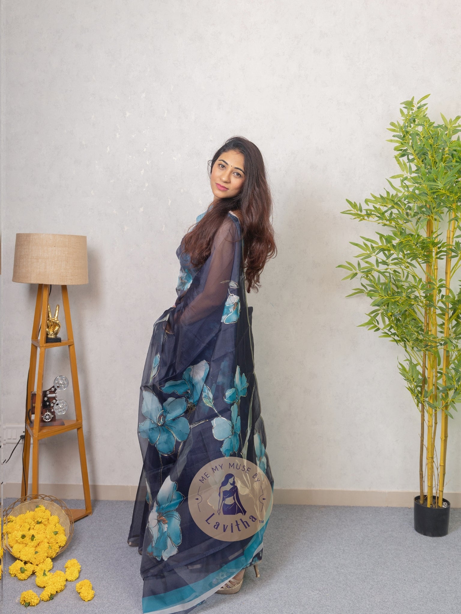 Our muse in a dark blue organza printed saree with floral patterns and thin gold border from Me My Muse by Lavitha