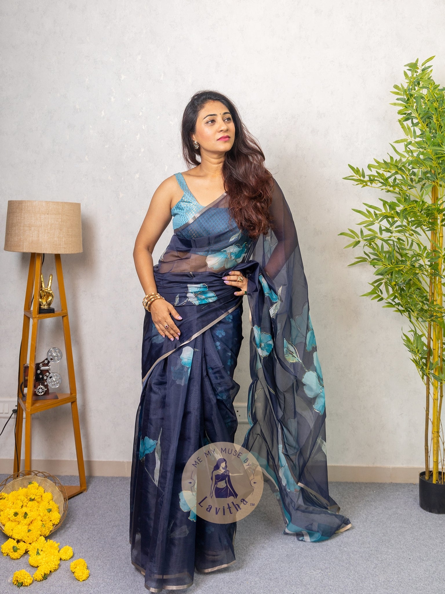 Our muse in a dark blue organza printed saree with floral patterns and thin gold border from Me My Muse by Lavitha