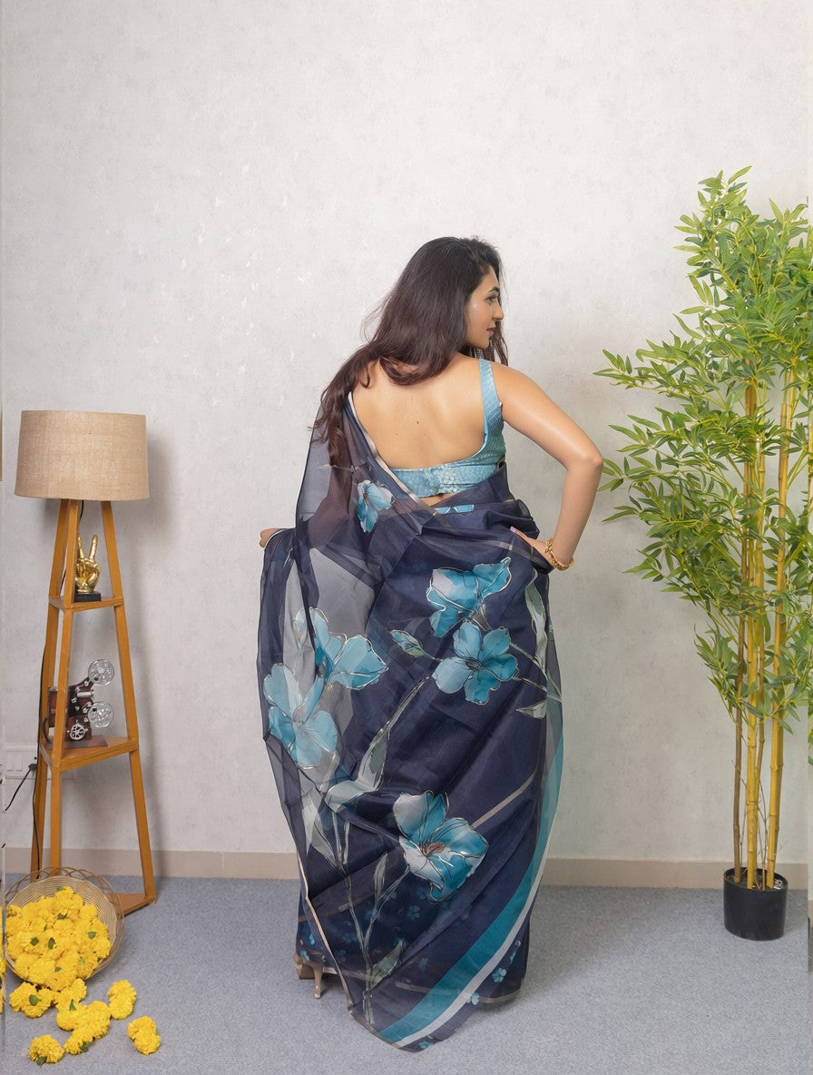 Our muse in a dark blue organza printed saree with floral patterns and thin gold border from Me My Muse by Lavitha