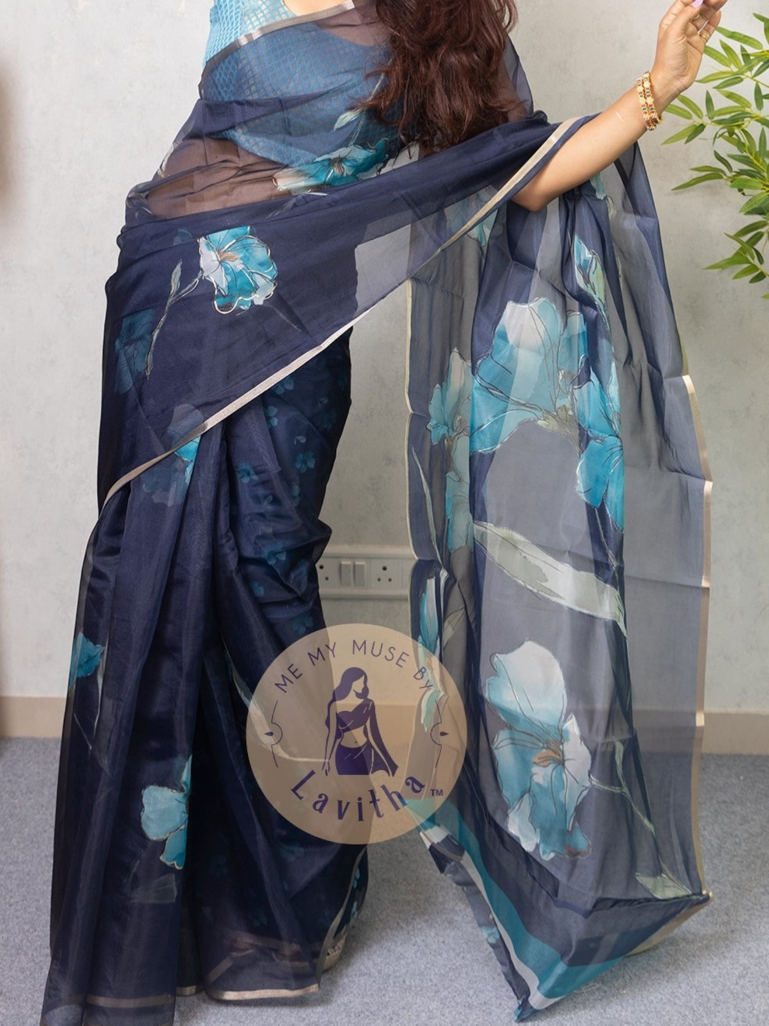 Our muse in a dark blue organza printed saree with floral patterns and thin gold border from Me My Muse by Lavitha